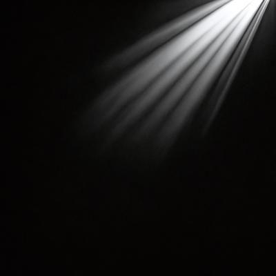 The primary subject of the image is a light source, which is shining brightly in the darkness. The setting is a black background, creating a dramatic contrast between the light and the darkness. The visual style is a close-up of the light source, emphasizing its intensity and creating a striking contrast. The colors and mood of the image are predominantly dark, with the light source being the only source of illumination, creating a sense of mystery and intrigue.